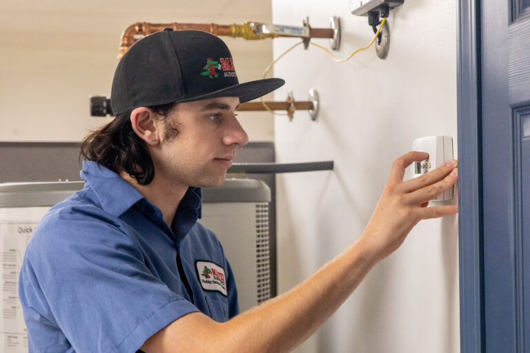 HVAC technician checking thermostat