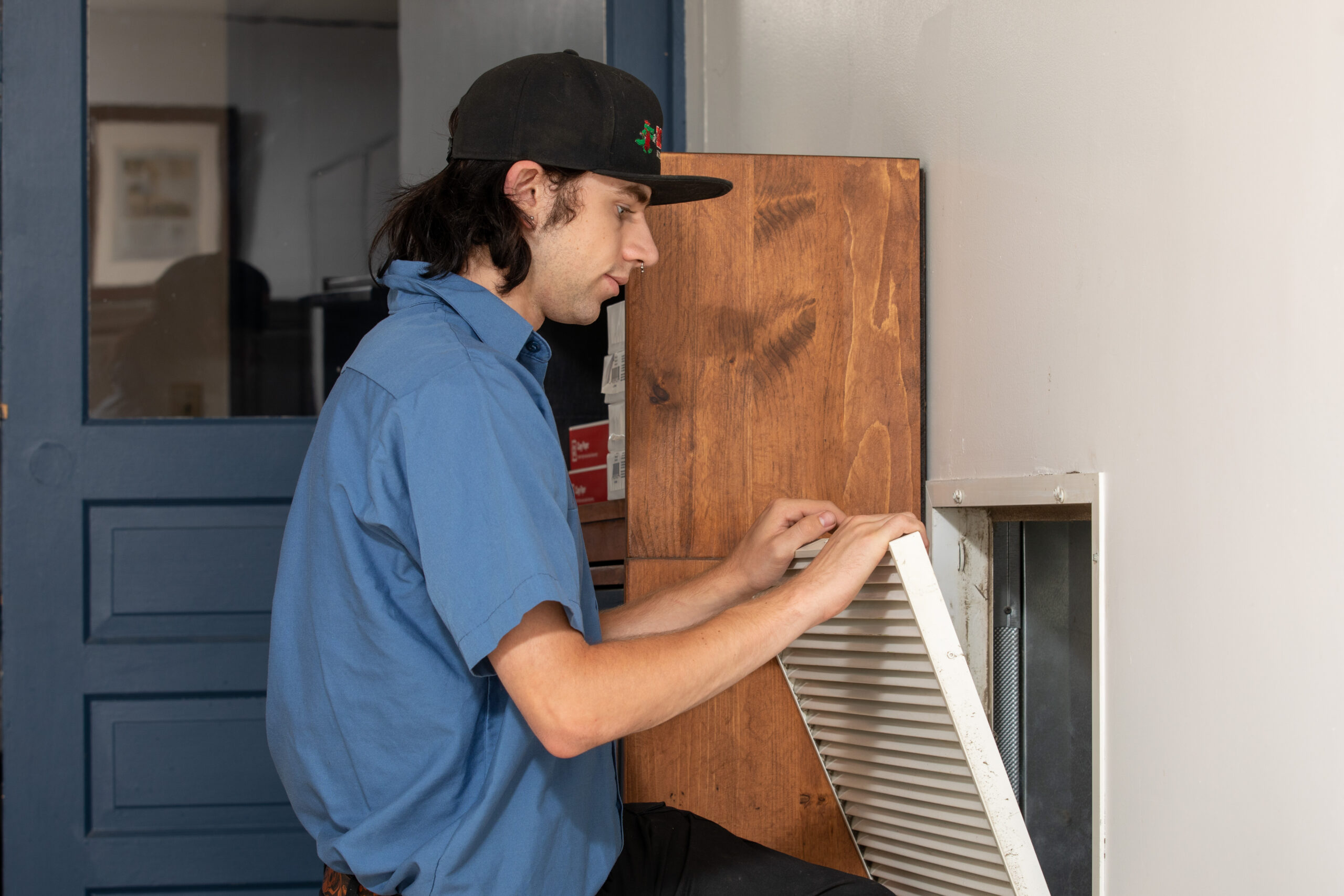 Technician changing HVAC system air filter